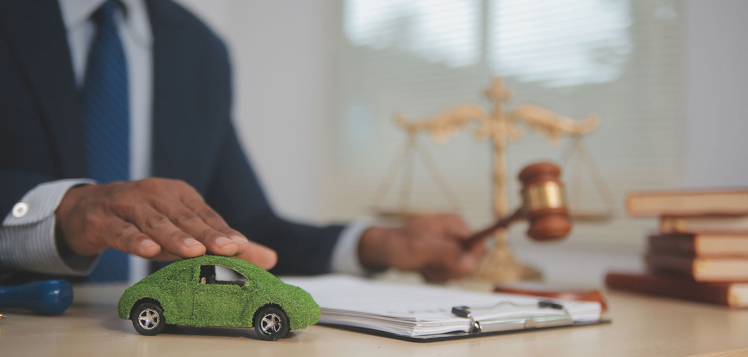 Judge’s gavel and a small car model on a desk, symbolizing Queens car accident lawsuits and insurance claims after a crash.